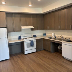 A kitchen with white appliances and brown cabinets