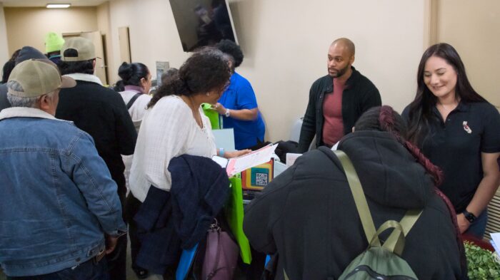 Travis Gaddishaw-Grant and Danielle Montero assist visitors at a table during the "For the Culture" event.